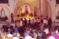 President Carolann Vattuone presenting new members with medals = La Presidentessa Carol Ann Vattuone offre una medaglietta ai nuovi membri della confraternita.